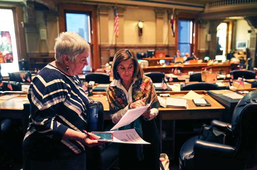In this Jan. 22, 2014 photo, Colorado Democratic state senators Mary Hodge, left, and Gail Schwartz talk inside the chambers of the Colorado State Senate, at the Capitol, in Denver. Sen. Hodge has proposed a bill requiring better informing landowners and buyers about their property rights, which often doesn't include mineral rights below the surface. (AP Photo/Brennan Linsley)
