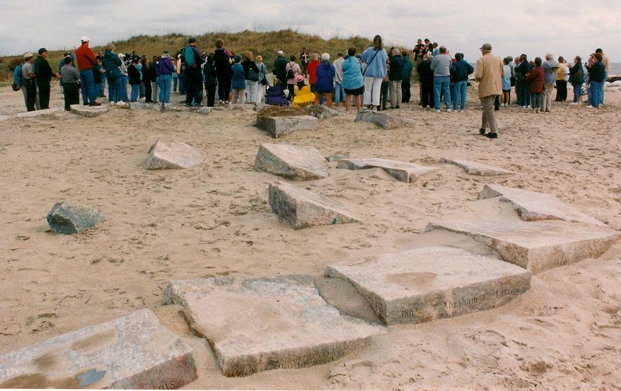 In an 2003 photo provided by Bruce Roberts, a large group gatheres to commemorate the 200th anniversary of light at Cape Hatteras that began with the first light in 1803. A storm had just passed through and tossed the stones around like toys. When the Cape Hatteras Lighthouse was moved 15 years ago, the stones were left behind at the erosion-prone spot on the Atlantic. Hatteras Island residents want the stones moved to the lighthouse so that they are publicly visible year-round and better protected from erosion. But the decision rests with the National Park Service, and so far there is no indication that the stones will be moved. (AP Photo/Bruce Roberts)