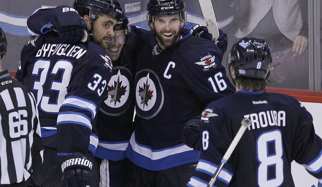 Winnipeg Jets&#x27; Dustin Byfuglien (33), Bryan Little, Andrew Ladd (16) and Jacob Trouba (8) celebrate Byfuglien&#x27;s overtime goal that gave the Jets a 5-4 win over the Toronto Maple Leafs in an NHL hockey game Saturday, Jan. 25, 2014, in Winnipeg, Manitoba. (AP Photo/The Canadian Press, Jason Woods)