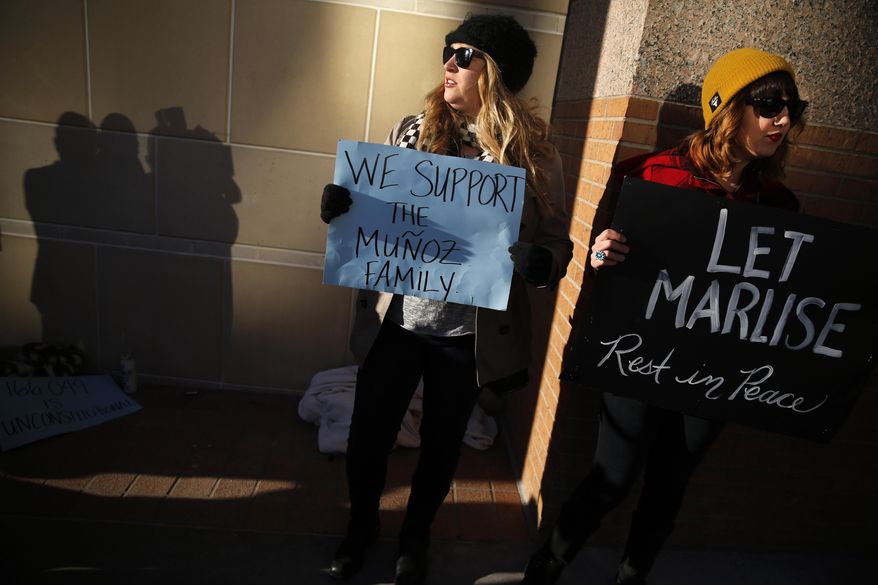 Autumn Brackeen, left, and Afton Brown, right, both of Fort Worth, Texas show their support for the Munoz family outside the Tim Curry Criminal Justice Center, Friday, Jan. 24, 2014, in Fort Worth, Texas after a judge ruled in Marlise Munoz life or death case. Erick Munoz's wife Marlise is brain dead and on life support with his unborn child at John Peter Smith Hospital. The judge has sided with the family of Marlise Munoz and ordered John Peter Smith Hospital to declare the pregnant woman dead and withdraw life support by 5 p.m. Monday. (AP Photo/The Dallas Morning News, Tom Fox)