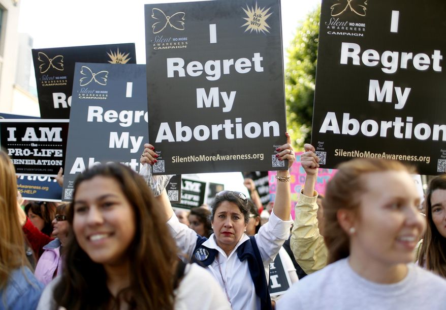 Abortion opponent Georgette Forney holds a sign stating "I regret my abortion" during the "Walk for Life" rally and march, Saturday, Jan. 25, 2014, in San Francisco. Thousands of abortion opponents marched through downtown San Francisco for the 10th annual "Walk for Life West Coast." The protesters rallied at Civic Center Plaza in front of City Hall before marching down Market Street to Justin Herman Plaza. (AP Photo/Beck Diefenbach)