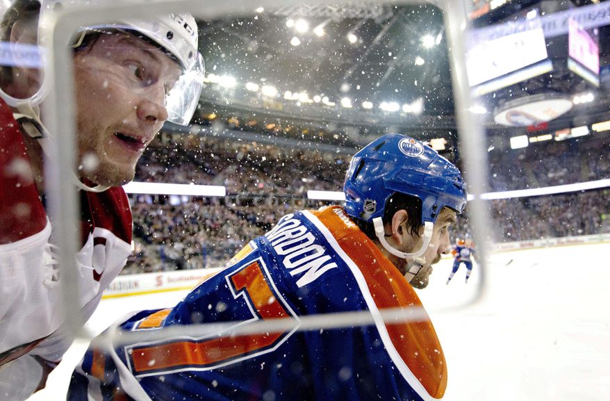 Phoenix Coyotes&#x27; Shane Doan (19) is checked by Edmonton Oilers&#x27; Boyd Gordon (27) during the first period of an NHL hockey game Friday, Jan. 24, 2014, in Edmonton, Alberta. (AP Photo/The Canadian Press, Jason Franson)