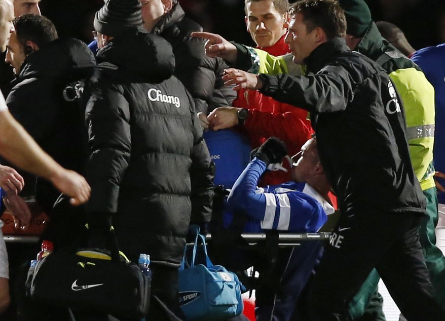 Everton's Bryan Oviedo is carried off the pitch after an injury during their English FA Cup fourth round soccer match against Stevenage at the Lamex Stadium, Stevenage, England, Saturday, Jan. 25, 2014. (AP Photo/Sang Tan)
