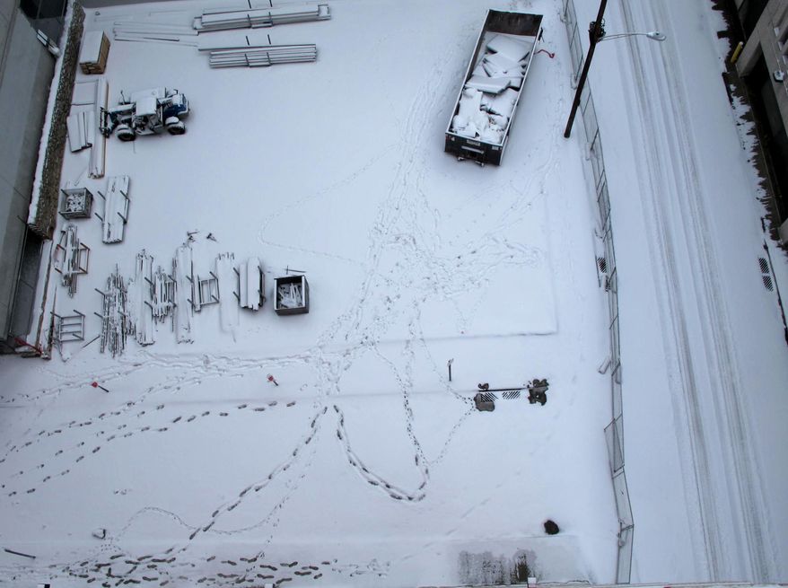 construction zone in downtown Cincinnati is shown blanketed in snow and crisscrossed with footprints Saturday, Jan. 25, 2014, after fresh snow fell across Ohio overnight Saturday and was continuing in the morning, creating hazardous driving conditions that caused several crashes. (AP Photo/Amanda Lee Myers)