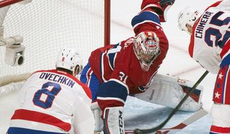 Washington Capitals&#39; Alex Ovechkin, left, and teammate Jason Chimera, right, move in on Montreal Canadiens goaltender Carey Price during the second period of an NHL hockey game in Montreal, Saturday, Jan. 25, 2014. (AP Photo/The Canadian Press, Graham Hughes)