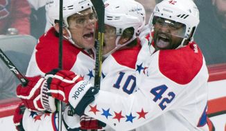 Washington Capitals&#39; Alex Ovechkin, left, celebrates with teammates Martin Erat, center, and Joel Ward after Ovechkin scored against the Montreal Canadiens during the second period of an NHL hockey game in Montreal, Saturday, Jan. 25, 2014. (AP Photo/The Canadian Press, Graham Hughes)