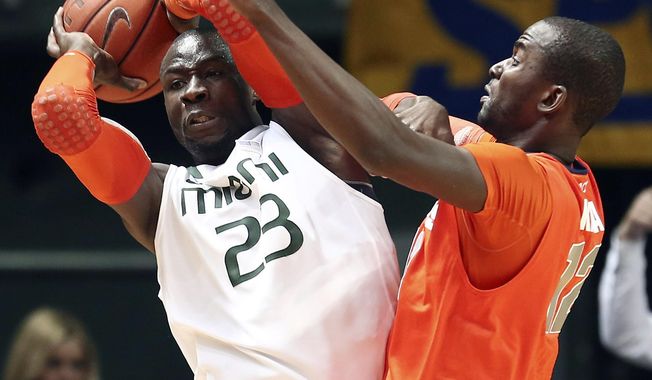Syracuse&#x27; Baye Moussa Keita, right, pressures Miami&#x27;s Russ DeRemer (23) during the first half of an NCAA college basketball game in Coral Gables, Fla., Saturday, Jan. 25, 2014. (AP Photo/J Pat Carter)
