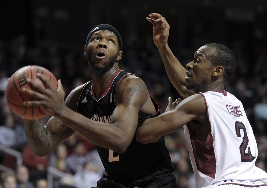 Cincinnati's Titus Rubles (2) drives past Temple's Will Cummings during the first half of an NCAA college basketball game on Sunday, Jan. 26, 2014, in Philadelphia. (AP Photo/Michael Perez)