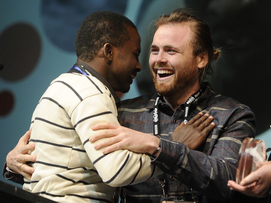 Cutter Hodierne, right, director of "Fishing Without Nets," is embraced by cast member Abdikani Muktar after winning the Directing Award: Dramatic for his film during the 2014 Sundance Film Festival Awards Ceremony on Saturday, Jan. 25, 2014, in Park City, Utah. (Photo by Chris Pizzello/Invision/AP)