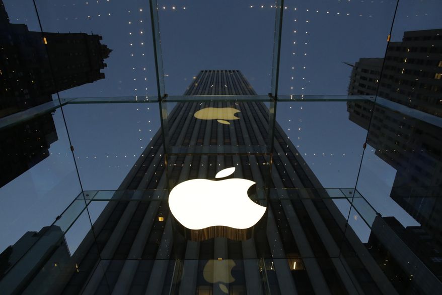 FILE - In this Wednesday, Nov. 20, 2013, file photo, the Apple logo is illuminated in the entrance to the Fifth Avenue Apple store, in New York. Apple Inc. reports quarterly financial results after the market closes Monday, Jan 27, 2014. (AP Photo/Mark Lennihan, File)