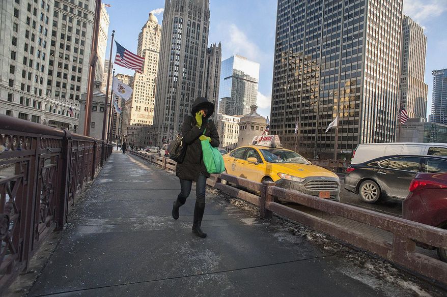 A woman walks briskly across the Michigan Avenue Bridge in Chicago, Monday morning Jan. 27, 2014, as temperatures were near zero at the start of the day and expected to fall throughout the day. Below-zero high temperatures expecting to last 2 1/2 days have returned to many parts of the Midwest bringing with it wind chills ranging from the negative teens to temperatures colder than 40 below zero. (AP Photo/Sun-Times Media, Michael R. Schmidt) MANDATORY CREDIT, MAGS OUT, NO SALES