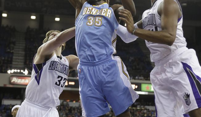 Denver Nuggets forward Kenneth Faried, center, grabs a rebound between Sacramento Kings&#x27; Aaron Gray, left, and Jason Thompson during the first quarter of an NBA basketball game in Sacramento, Calif., Sunday, Jan. 26, 2014. (AP Photo/Rich Pedroncelli)
