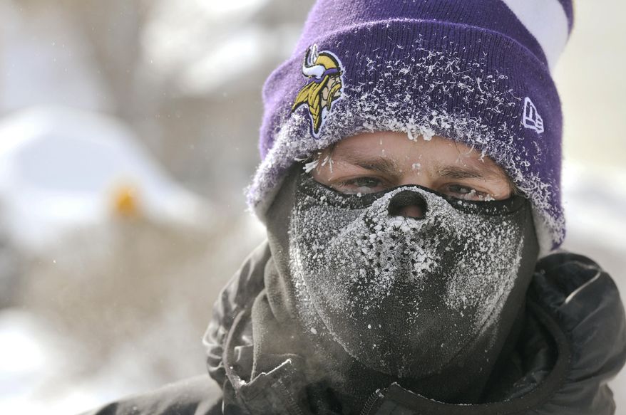 Mark Kovacich shows the effects of the morning's 18 degree below zero temperature as he takes a break from shoveling snow in Virginia, Minn., Mnday, Han. 27, 2014. Subzero temperatures, high winds and drifting snow have closed schools and major roadways in Minnesota, with state officials cautioning against unnecessary travel. (AP Photo/Mesabi Daily News, Mark Sauer)