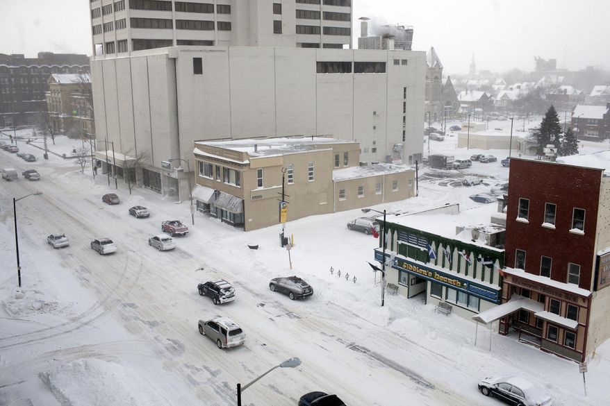 Drivers gingerly work their way south on Indiana 933 past the Chase Tower on Monday, Jan. 27, 2014, in downtown South Bend. Sub-freezing temperatures and blowing snow returned to the Michiana area yet again as the City of South Bend declared a winter weather emergency. (AP Photo/South Bend Tribune, James Brosher)