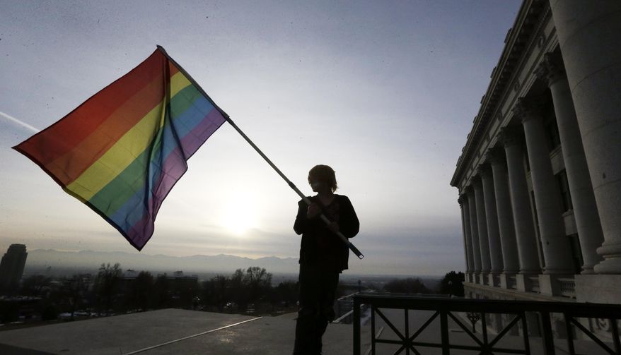 **FILE** Corbin Aoyagi, a supporters of gay marriage, waves his flag during a rally at the Utah State Capitol, Tuesday, Jan. 28, 2014, in Salt Lake City. Opponents and supporters of gay marriage held twin rallies at the Capitol on Tuesday. More than 1,000 gay couples rushed to get married when a federal judge overturned Utah's constitutional amendment banning same-sex marriage in late December 2013. In early January the U.S. Supreme Court granted Utah's request for an emergency halt to the weddings. (AP Photo/Rick Bowmer)