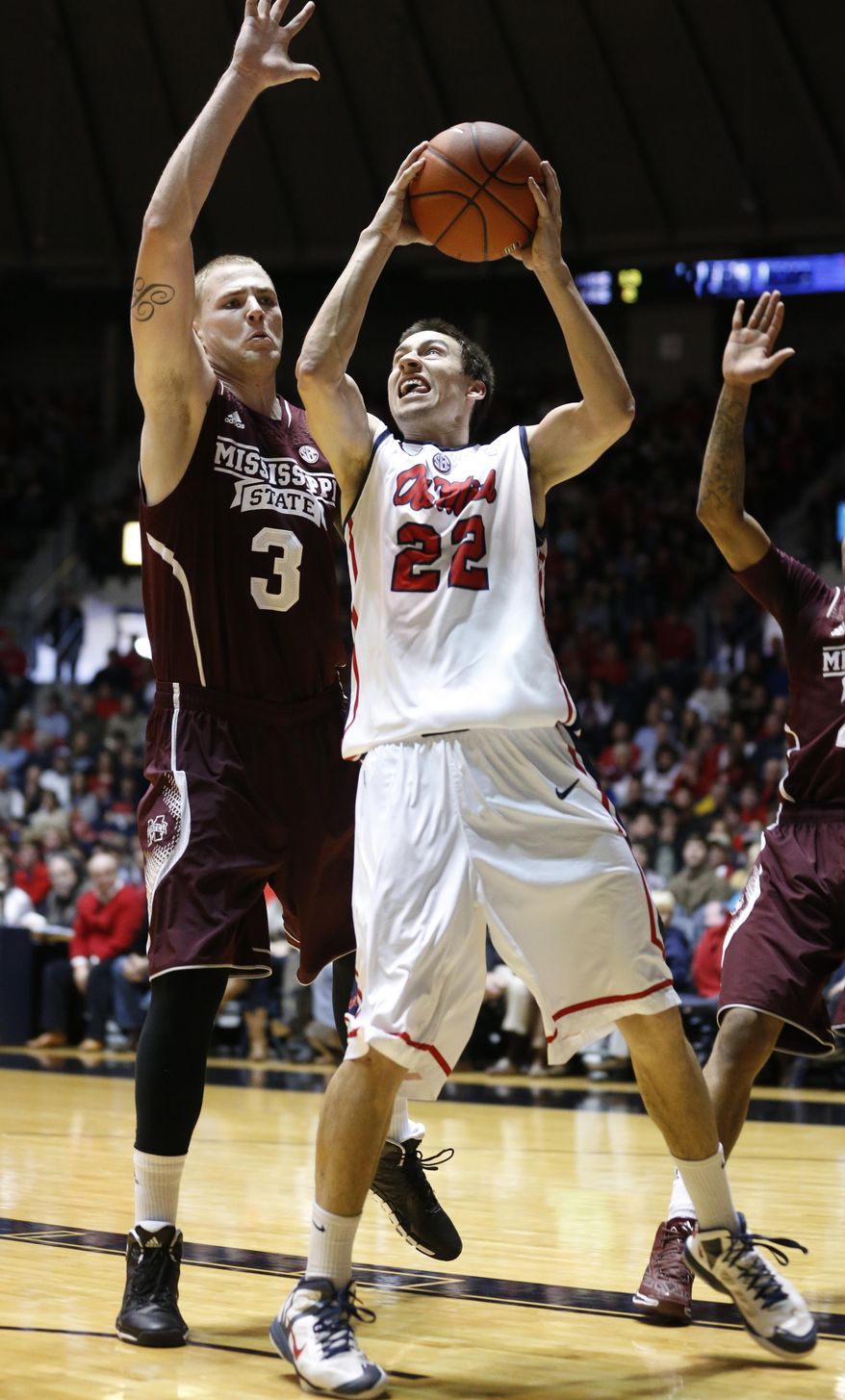 Mississippi guard Marshall Henderson (22) tries a shot at the basket as Mississippi State forward Colin Borchert (3) defends in the first half of an NCAA college basketball game in Oxford, Miss., Saturday, Jan. 25, 2014. (AP Photo/Rogelio V. Solis)