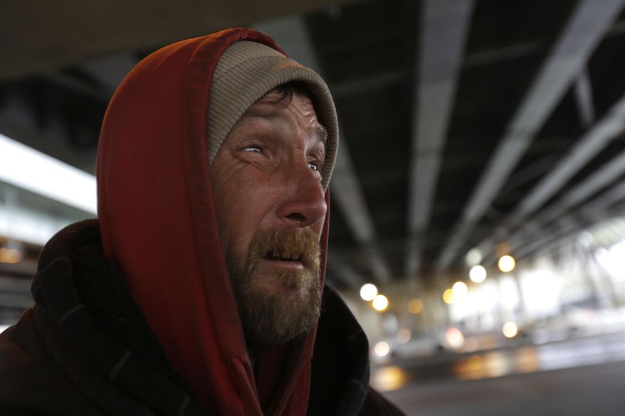 Jason Morrow, who is homeless, huddles in blankets to keep warm under the Pontchartrain Expressway in downtown New Orleans, Tuesday, Jan. 28, 2014. The third and nastiest arctic blast of the season hit Louisiana on Tuesday, as freezing rain began to fall and the rare possibility of snow tonight looms .(AP Photo/Gerald Herbert)