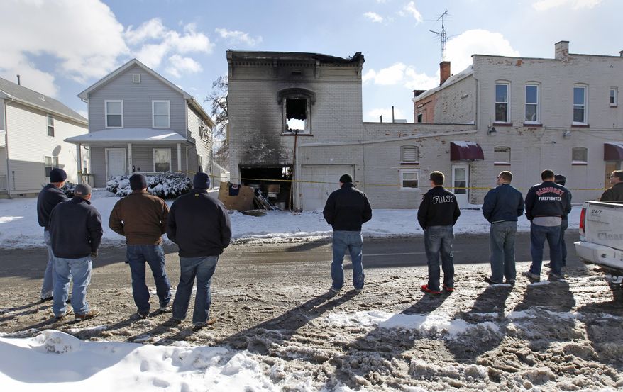 Firefighters from the Sandusky and Perkins Township, Ohio, fire departments view the apartment building in North Toledo, Monday, Jan. 27, 2014, where two Toledo firefighters were killed while battling a fire on Sunday. Firefighters Stephen A. Machcinski and James A. Dickman were killed. Dickman was a Perkins Township firefighter before joining the Toledo department. (AP Photo/The Blade, Dave Zapotosky) MANDATORY CREDIT; MAGS OUT; NO SALES; TV OUT; SENTINEL-TRIBUNE OUT; MONROE EVENING NEWS OUT; TOLEDO FREE PRESS OUT.
