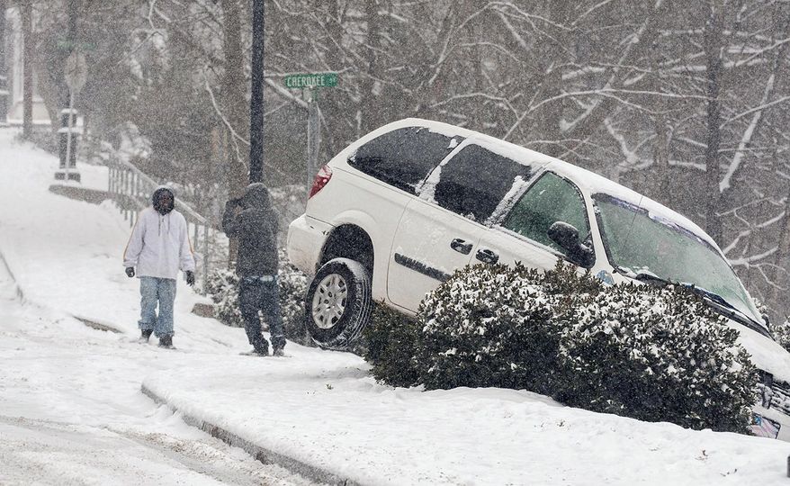 A vehicle ran off the road during a snow storm, Tuesday, Jan. 28, 2014 in Canton, Ga. A winter storm that would probably be no big deal in the North all but paralyzed the Deep South on Tuesday, bringing snow, ice and teeth-chattering cold, with temperatures in the teens in some places. (AP Photo/The Marietta Daily Journal, Kelly J. Huff) ATLANTA JOURNAL CONSTITUTION OUT; MAGS OUT; NO SALES