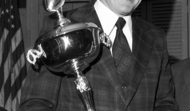 FILE - In this Feb. 5, 1973, file photo, University of Pennsylvania football coach Harry Gamble holds his trophy presented by the Football Writers Association of New York in New York. Gamble, who coached the Philadelphia Eagles as well as Lafayette, Penn and New Jersey high school teams before retiring as the Eagles&#x27; president, died Tuesday, Jan. 28, 2014, the Eagles said in a statement. He was 83. (AP Photo/John J. Lent, File)