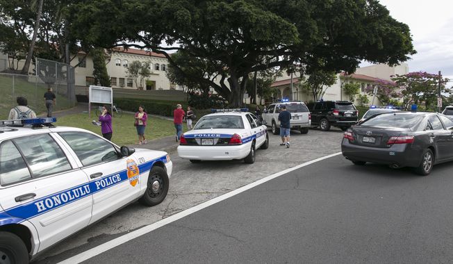Police respond to the campus of Roosevelt Hight School, after a shooting, Tuesday, Jan. 28, 2014, in Honolulu.  A police officer shot a 17-year-old runaway in the wrist at the high school after the teen cut one officer with a knife and punched two others, authorities said.  State Department of Education spokeswoman Donalyn Dela Cruz said the boy showed up Tuesday morning at Roosevelt High School. Officials there recognized him as a runaway who was not registered for classes, and called police.  Maj. Richard Robinson, commander of the Honolulu Police Department’s Criminal Investigations Division, said the boy lunged at officers who arrived at the public high school near downtown Honolulu and tried to take him into custody. (AP Photo/Marco Garcia)
