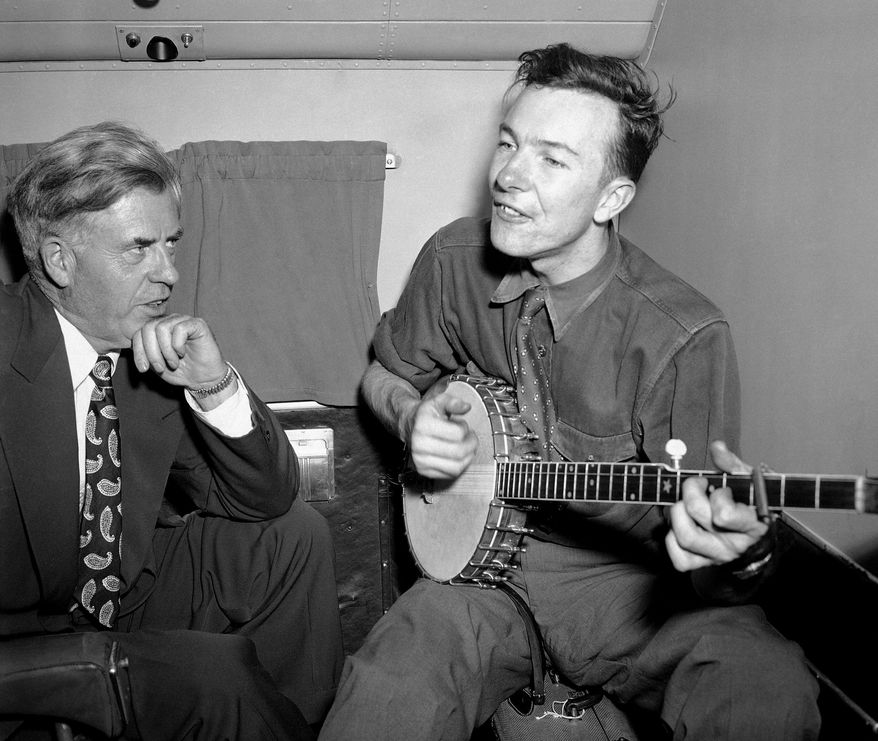 FILE - In this Aug. 28, 1948 file photo, Henry A. Wallace, Progressive Party presidential candidate, listens to Pete Seeger on a plane between Norfolk and Richmond, Va. Seeger died on Monday Jan. 27, 2014, at the age of 94. (AP Photo/File)