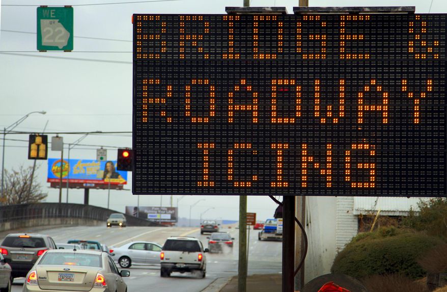 A sign alongside 13th Street near 10th Avenue in Columbus, Ga., warns westbound motorists Tuesday, Jan. 28, 2015 of potential icing on the bridge due to wintry precipitation. Georgians stocked up on ice-melting chemicals, school systems closed, and road crews prepared to clear snow and ice from highways as a winter storm took aim. (AP Photo/Columbus Ledger, Mike Haskey)