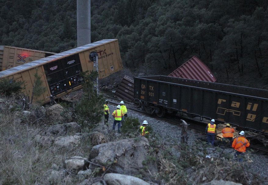 Emergency crews work on the scene of a train derailment under Interstate 5 near Gibson Road near Lakehead in Shasta County, Calif., on Monday, Jan. 27, 2014. The train was carrying recycled paper products and there was no hazardous waste spill. There were no injuries, but train traffic through the area was expected to be delayed. (AP Photo/Record Searchlight, Greg Barnette)
