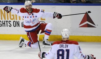 Washington Capitals defenseman Mike Green (52) celebrates his game winning goal with Dmitry Orlov (81) during the overtime session of an NHL hockey game against the Buffalo Sabres in Buffalo, N.Y., Tuesday, Jan. 28, 2014. Washington won 5-4. (AP Photo/Gary Wiepert)