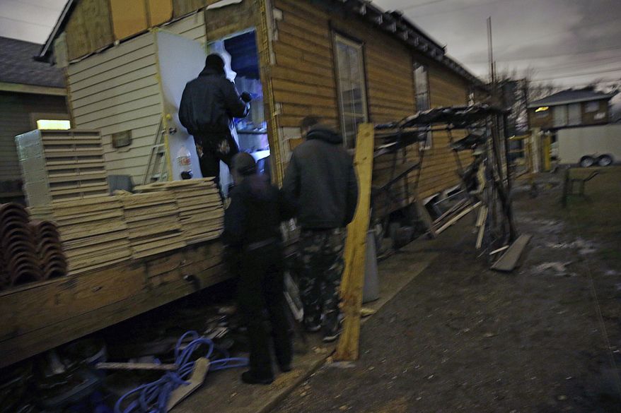Members of the New Orleans Police Department Homeless Assistance Unit, check on a report of a homeless person in an uninhabited building in New Orleans, Tuesday, Jan. 28, 2014. The third and nastiest arctic blast of the season hit Louisiana on Tuesday, as temperatures plummeted, freezing rain began to fall and the rare possibility of snow tonight looms. (AP Photo/Gerald Herbert)