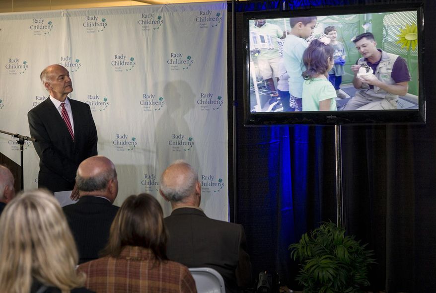 In this Dec. 18, 2013 photo provided by San Diego Zoo Global wildlife conservancy, Dr. Donald B. Kearns, acting president of Rady Children's Hospital in San Diego, gives a preview of what people can expect from San Diego Zoo Kids, a television network all about wild animals originating from the zoo. At the launch news conference, he described how sick or injured children need more than medical care to heal. The TV channel is one of those things because it will entertain, educate and distract patients. (AP Photo/San Diego Zoo Global, Ken Bohn)