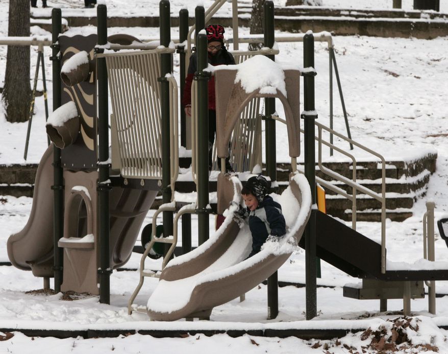 Snow and ice cover the play set at Emily Douglas Park in downtown Columbia, SC, Wednesday, Jan. 29, 2014, as children enjoy a snowday. Gov. Nikki Haley declared a state of emergency in South Carolina as a winter storm brought snow, sleet and freezing rain into the state. Schools and state and local government are closed for a second day. (AP Photo/Mary Ann Chastain)