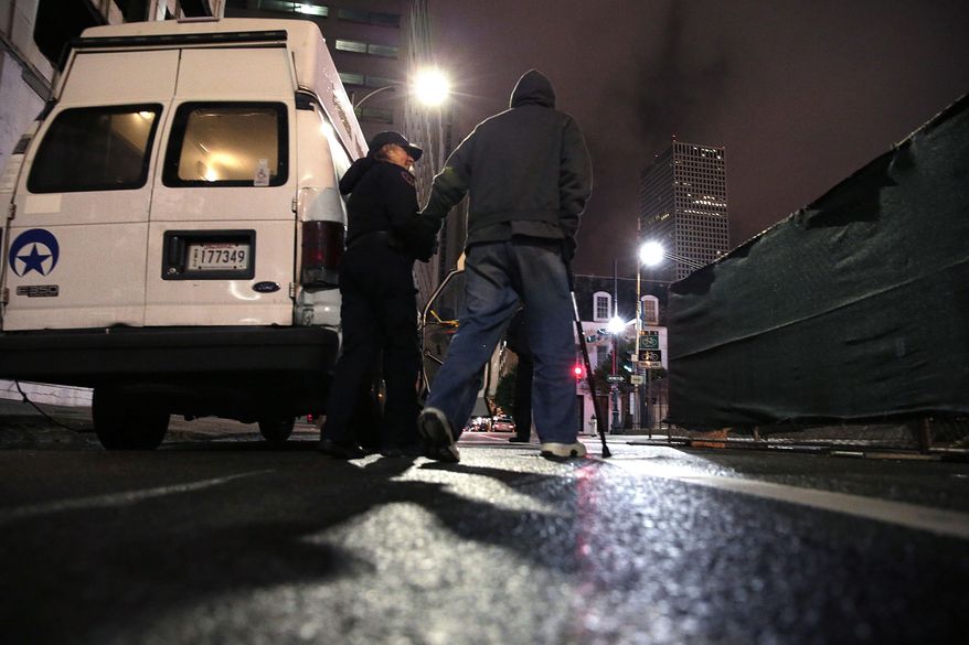 B.B. St. Roman, executive director of the New Orleans Police Department Homeless Assistance Unit, assists a homeless man to her van to transport him to a shelter, in New Orleans, Tuesday, Jan. 28, 2014. The third and nastiest arctic blast of the season hit Louisiana on Tuesday, as temperatures plummeted, freezing rain began to fall and the rare possibility of snow tonight looms. (AP Photo/Gerald Herbert)