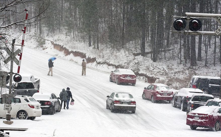 Motorists abandon their vehicles and start walking to their homes on Georgia Highway 140, Tuesday, Jan. 28, 2014 in Canton, Ga. A winter storm that would probably be no big deal in the North all but paralyzed the Deep South on Tuesday, bringing snow, ice and teeth-chattering cold, with temperatures in the teens in some places. (AP Photo/The Marietta Daily Journal, Kelly J. Huff) ATLANTA JOURNAL CONSTITUTION OUT; MAGS OUT; NO SALES