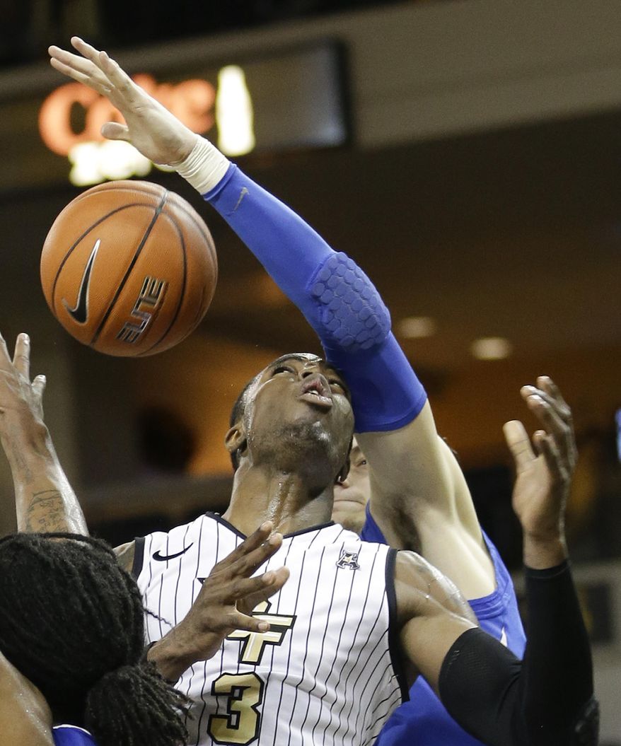 Central Florida's Isaiah Sykes (3) loses the ball as the arm of Memphis forward Austin Nichols reaches in to stop him from making a shot during the second half of an NCAA basketball game in Orlando, Fla., Wednesday, Jan. 29, 2014. Memphis won 69-59.(AP Photo/John Raoux)