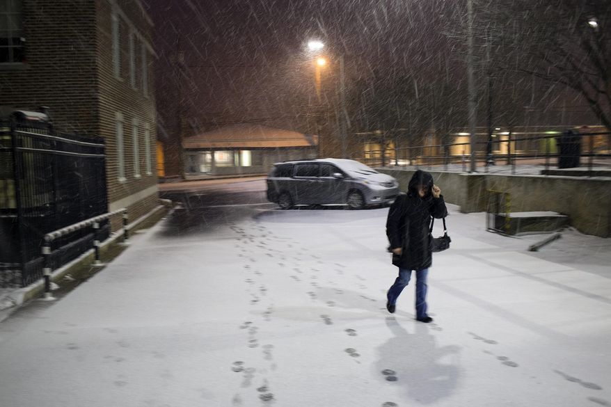 Megan McGowen walks through the snow, Tuesday, Jan. 28, 2014, in Auburn, Ala. A winter storm that would probably be no big deal in the North all but paralyzed the Deep South on Tuesday, bringing snow, ice and teeth-chattering cold, with temperatures in the teens in some places. (AP Photo/Opelika-Auburn News, Albert Cesare)
