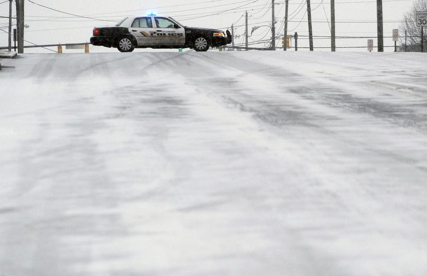 A Montgomery Police cruiser blocks an iced over road in downtown Montgomery, Ala. during the winter storm on Tuesday, Jan. 28, 2014. A winter storm that would probably be no big deal in the North all but paralyzed the Deep South on Tuesday, bringing snow, ice and teeth-chattering cold, with temperatures in the teens in some places. (AP Photo/The Montgomery Advertiser, Mickey Welsh) NO SALES