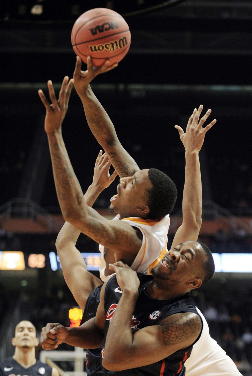 Tennessee guard Jordan McRae, top, shoots over a Mississippi player during the second half of an NCAA college basketball game Wednesday, Jan. 29, 2014, in Knoxville, Tenn. (AP Photo/Knoxville News Sentinel, Adam Lau)