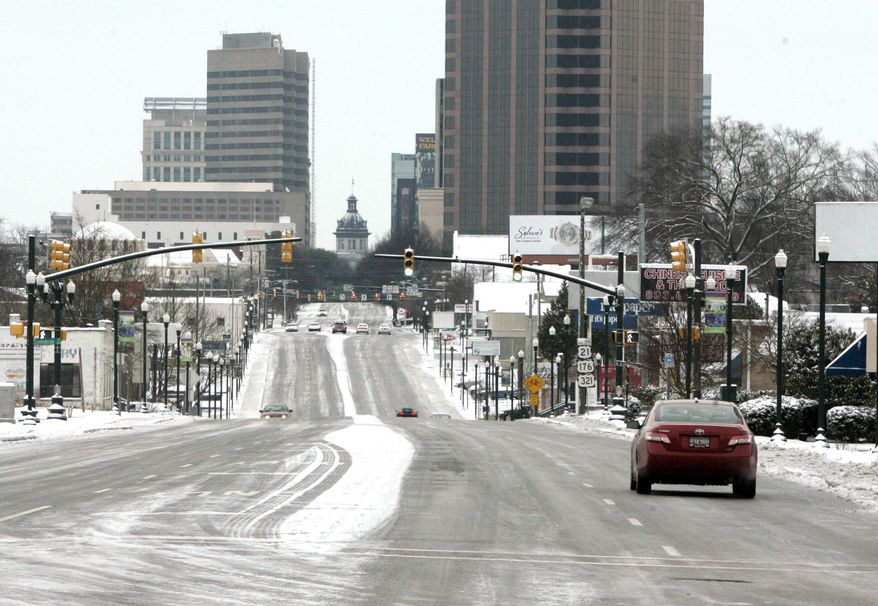Snow and ice cover the roads in downtown Columbia, S.C., Wednesday, Jan. 29, 2014. Gov. Nikki Haley declared a state of emergency in South Carolina as a winter storm brought snow, sleet and freezing rain into the state. Schools and state and local government are closed for a second day. (AP Photo/Mary Ann Chastain)