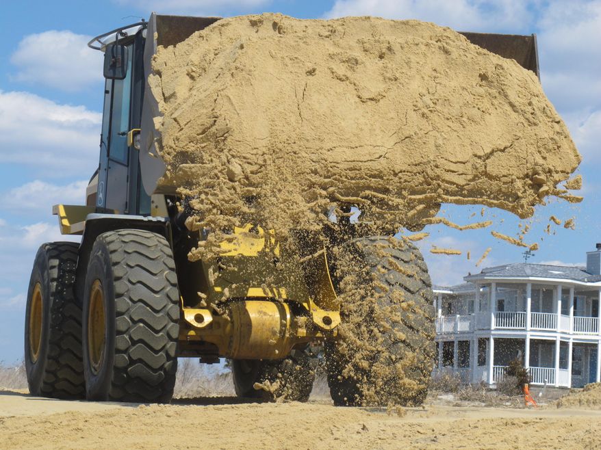 In this April 2, 2013 photo, a front-end loader deposits sand on Delaware Bay Beach in Middle Township, N.J., that was badly eroded by Superstorm Sandy. Some Delaware Bay communities say their losses from the storm have been overshadowed by more extensive damage along the ocean, and are backing a proposed national fund to prevent and respond to severe weather emergencies. (AP Photo/Wayne Parry)