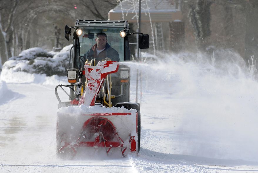 City employee William Fryer clears the sidewalks along the bluff in downtown St. Joseph, Mich., Tuesday, Jan. 28, 2014. Temperatures dropped to as low as double-digits below zero in Michigan as the state faced a day of dangerously cold weather. (AP Photo/The Herald-Palladium, Don Campbell)