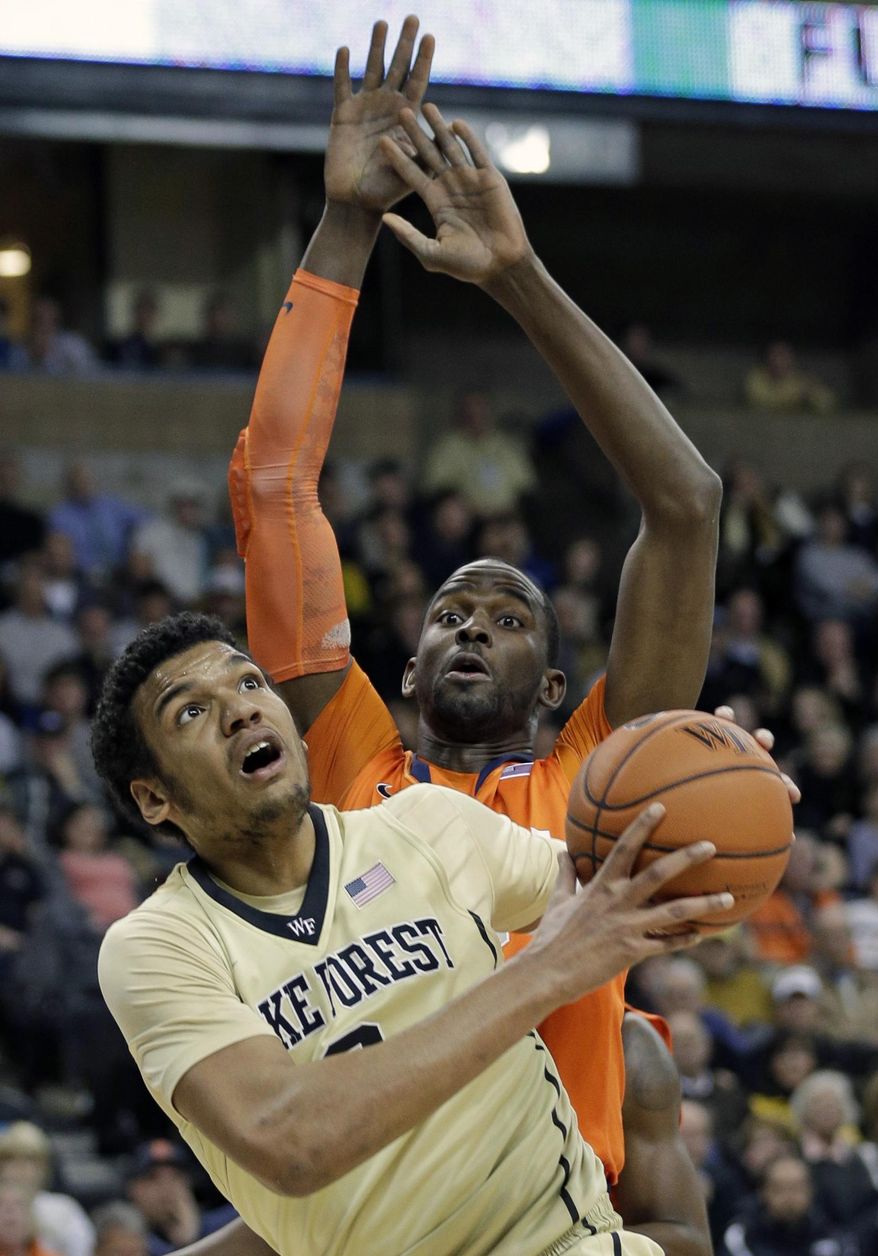 Wake Forest's Devin Thomas, front, drives to the basket against Syracuse's Baye Moussa Keita, back, during the first half of an NCAA college basketball game in Winston-Salem, N.C., Wednesday, Jan. 29, 2014. (AP Photo/Chuck Burton)