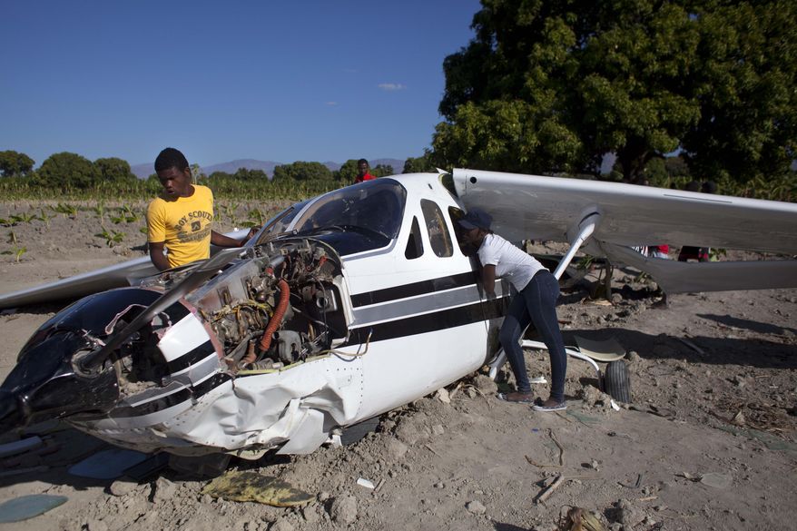 Residents check out a Cessna Super Skymaster that made an emergency landing the night before in a field just outside Cabaret, a coastal town northwest of Port-au-Prince, Haiti, Thursday Jan. 30, 2014. Haitian police said on Thursday that the small plane piloted by a U.S. citizen suffered mechanical problems and made an emergency landing in the banana field. Police inspector Joachin Antoine said that pilot Practor Antoine was treated for unspecified injuries at a hospital in the capital. A passenger named John Michael was not injured. (AP Photo/Dieu Nalio Chery)