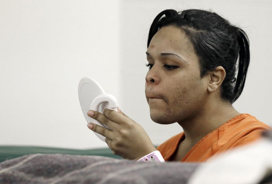 In this Dec. 10, 2013 photo Tyniehsa Stephens checks her image in a mirror in a new unit in the Harris County Jail for gay, bisexual and transgender inmates in Houston. Harris County is making changes in how they house its gay, lesbian, bisexual and transgender inmates stemming from a law passed under former President George W. Bush requiring federal, state and local lockups to eliminate rape. (AP Photo/Pat Sullivan)