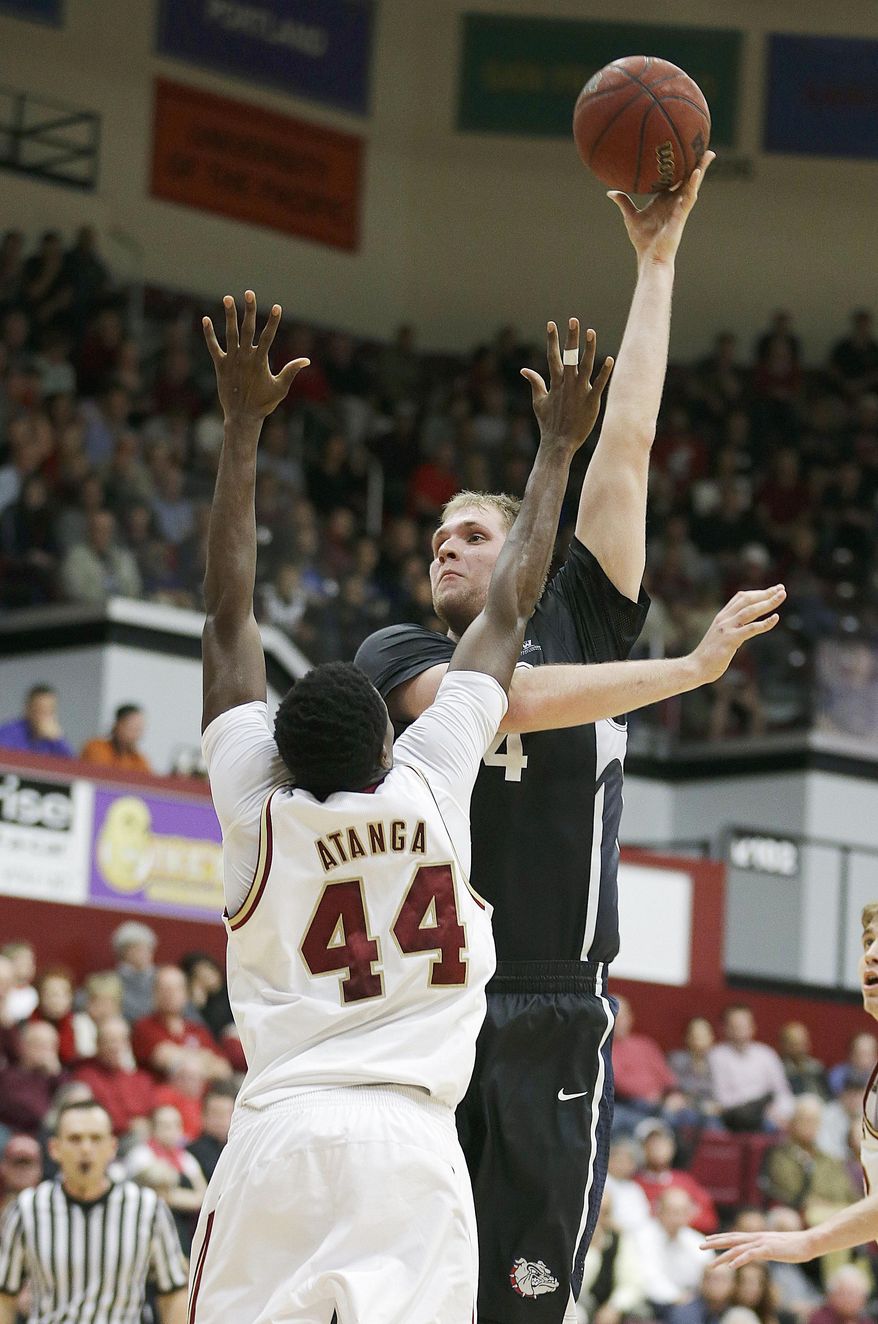 Gonzaga center Przemek Karnowski, right, takes a shot over Santa Clara forward Yannick Atanga (44) in the first half of an NCAA college basketball game Wednesday, Jan. 29, 2014, in Santa Clara, Calif. (AP Photo/Tony Avelar)