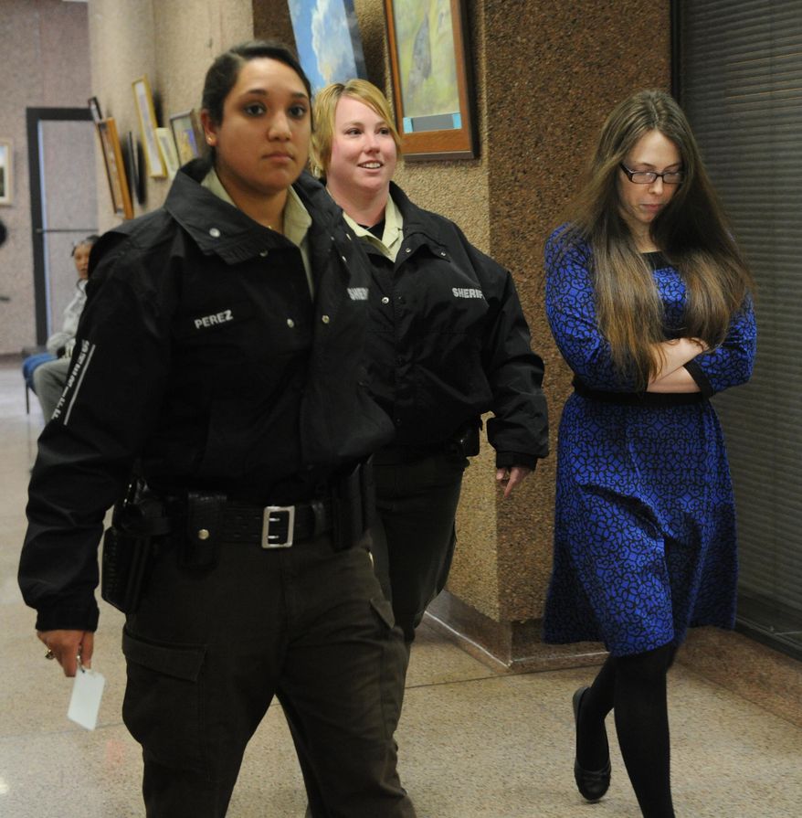 In this photo from Jan. 27, 2014, escorted by sheriff's deputies, Tiffany Klapheke, right, leaves the jury selection room at the Taylor County Courthouse in Abilene, Texas. Klapheke is with injury to a child in the August 2012 death of her 22-month-old daughter, Tamryn Klapheke, who died of malnutrition and dehydration. (AP Photo/Abilene Reporter-News, Nellie Doneva)