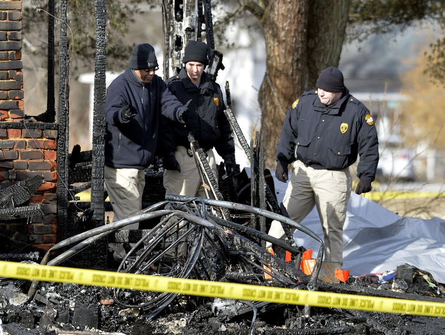 Kentucky State Fire investigators work at the scene of early morning house fire in Depoy, Ky. Thursday Jan. 30, 2014. As many as nine people were killed early Thursday in a house fire in rural western Kentucky and two people were taken to a hospital for treatment, officials said. Eleven people lived in the home in the Depoy community of Muhlenberg County, Greenville Assistant Fire Chief Roger Chandler said. (AP Photo/Timothy D. Easley)