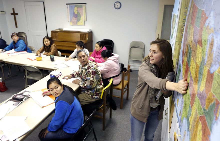 Volunteer teacher Alicia Soppe, right, goes over the Louisiana Purchase during a Burmese civic class made possible by U.S. Committee for Refugees and Immigrants office at First United Methodist Church Wednesday, Jan. 29, 2014, in Waterloo, Iowa. (AP Photo/Waterloo Courier, Matthew Putney)