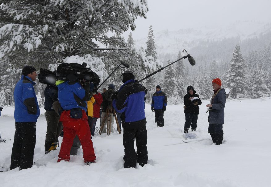 Frank Gehrke, chief of the California Cooperative Snow Survey Program for the Department of Water Resources, right, outlines for reporters his findings after conducting the second snow survey of the year near Echo Summit, Calif., Thursday, Jan. 30, 2014. Despite the overnight snow storm the survey showed the snow depth at 12.4 inches with a water content of only 1.4 inches for this location at this time of the year. Gehrke said that while the recent snow fall will help, it is not enough to impact the water supply.(AP Photo)