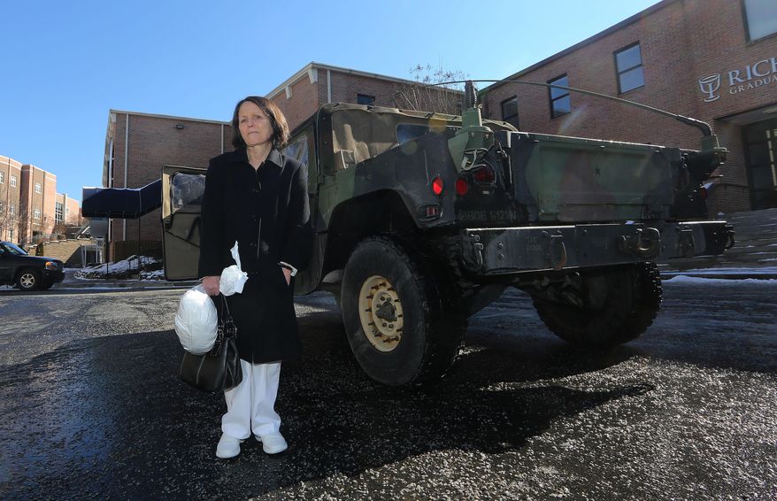 Lila Gunter waits next to a Georgia National Guard vehicle before they take her to pick up her car after it was towed in the winter storm that swept across the state Thursday, Jan. 30, 2014, in Atlanta. The Guard and the Georgia State Patrol are offering rides to motorist who had in abandon their cars. (AP Photo/John Bazemore)